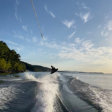 really cool dude jumping the wake on a wakeboard. he is absolutely shredding